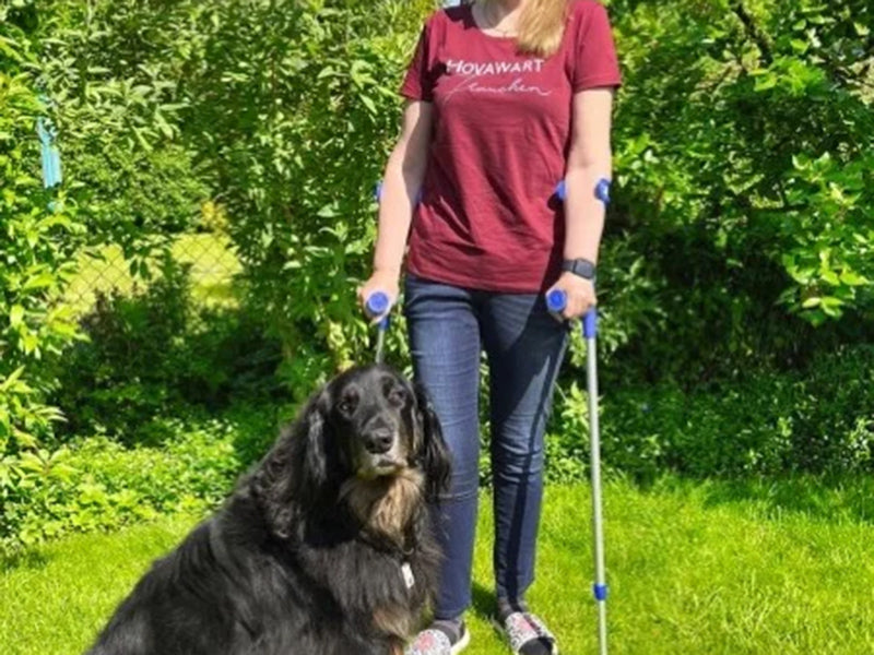 Frau mit Krücken und Hund