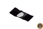 Geöffnete, schwarze AirTag-Tasche mit Klettverschluss. Ein silberner und weißer Apple AirTag liegt in der Mitte der Halterung.