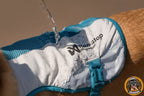 Nahaufnahme einer blauen und weißen Non-stop dogwear Kühlweste für Hunde, auf die Wasser gegossen wird.
