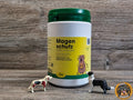 Nahaufnahme der Dose "Magenschutz Gastric Protection" zur Regeneration des Magen-Darm-Traktes bei Hunden mit Sodbrennen und Licky Fits. Davor stehen zwei Hunde-Spielfiguren.