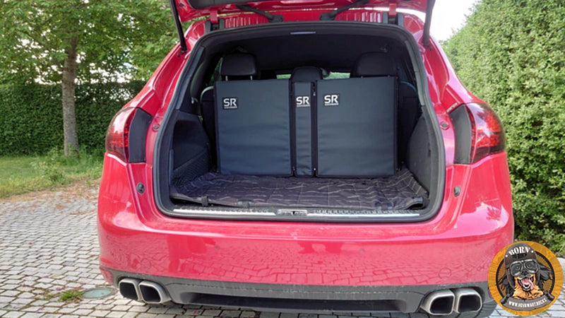 Das komplette Saferider Hundesystem im Kofferraum eines roten SUV, gesehen von hinten. Die Module bedecken die gesamte Breite der Rückbank.