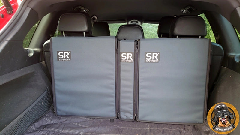 Das komplette Saferider Hundesicherungssystem mit zwei Basismodulen und einem kleineren Erweiterungsmodul im Kofferraum eines Autos eingebaut. Das System ist grau.