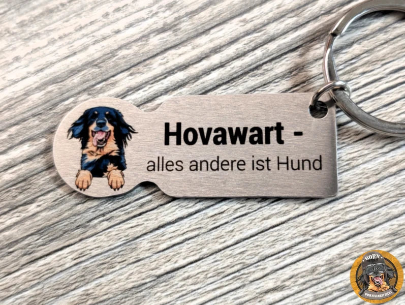 Silberner Hovawart-Schlüsselanhänger mit Illustration eines schwarzmarkenen Hovawarts und dem Schriftzug "Hovawart - alles andere ist Hund".