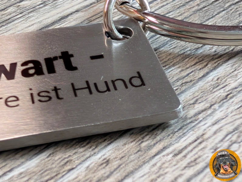 Detailansicht eines massiven silberfarbenen Hovawart-Schlüsselanhängers aus Metall mit der Gravur "Hovawart alles andere ist Hund".