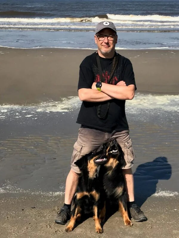 Mann mit großem Hund am Strand