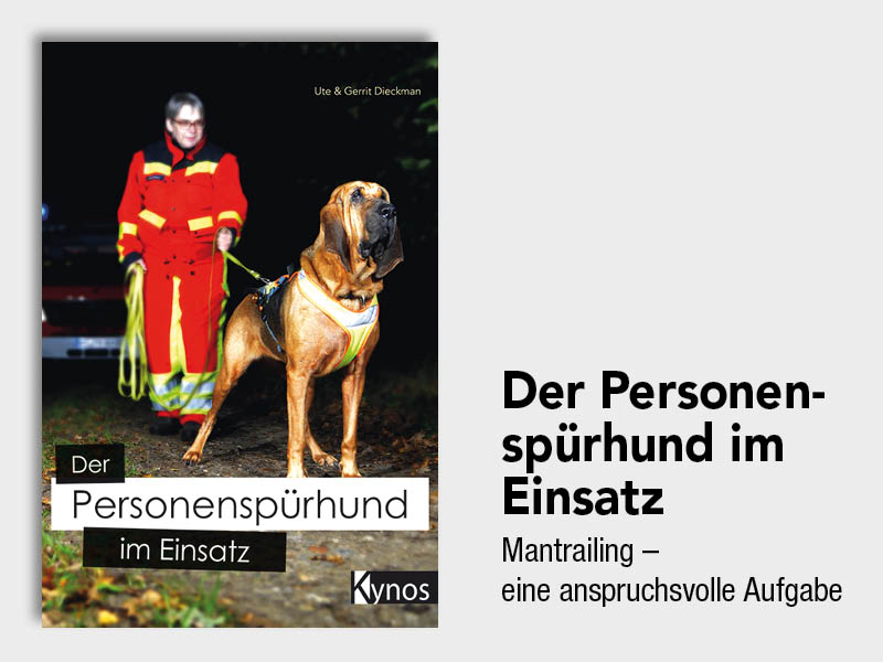 Cover des Buches "Der Personenspürhund im Einsatz" mit einer Rettungsperson in roter Jacke, die einen großen, hellbraunen Bloodhound-Hund an der Leine hält. Der Hund trägt ein gelbes Geschirr. Im Hintergrund sind dunkle Bäume und der Schein eines Einsatzfahrzeugs bei Nacht zu sehen.