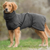 Hovawart-Hund, der nach einem Spaziergang im Regen oder Bad einen anthrazitfarbenen Bademantel trägt, der Feuchtigkeit aufnimmt und die Hunde warmhält.