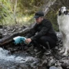 Kühlweste wird in einem Bach bei einer Wanderung mit Wasser getränkt