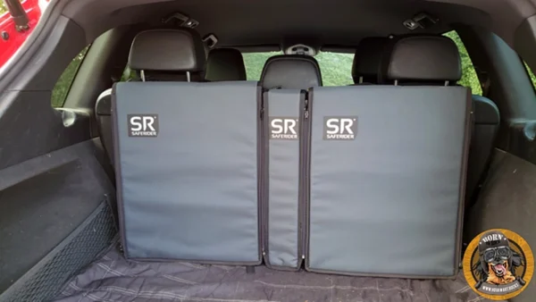 Das komplette Saferider Hundesicherungssystem mit zwei Basismodulen und einem kleineren Erweiterungsmodul im Kofferraum eines Autos eingebaut. Das System ist grau.
