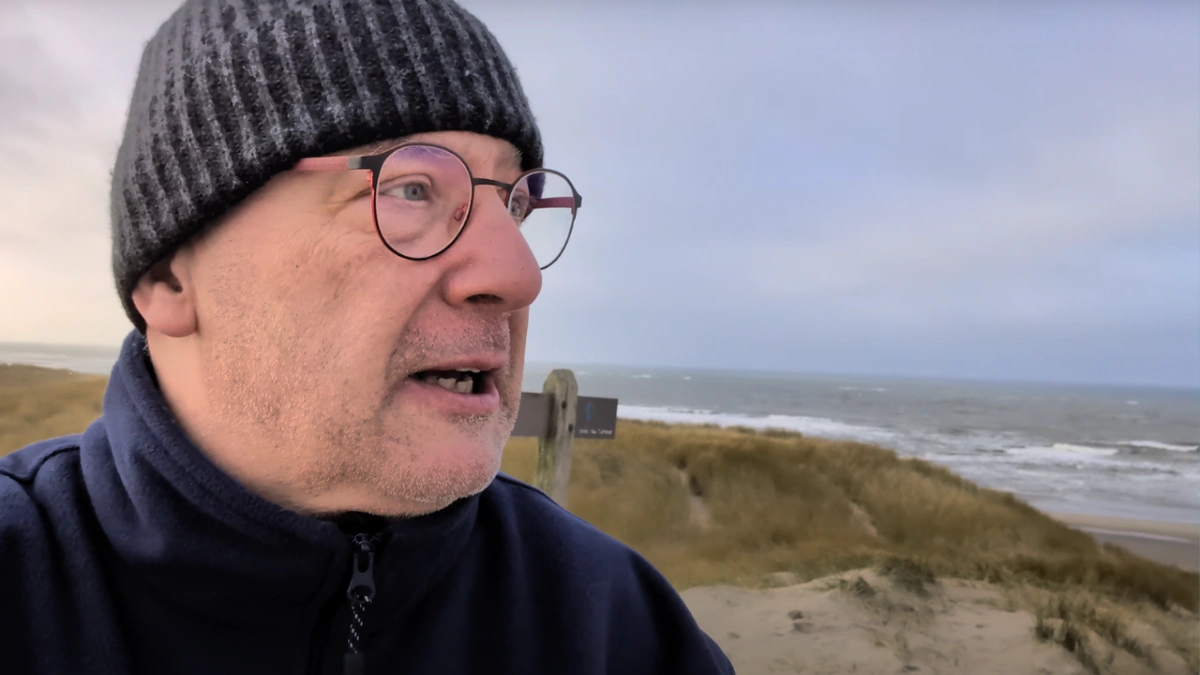 Herrchen trägt Fleecejacke am Strand